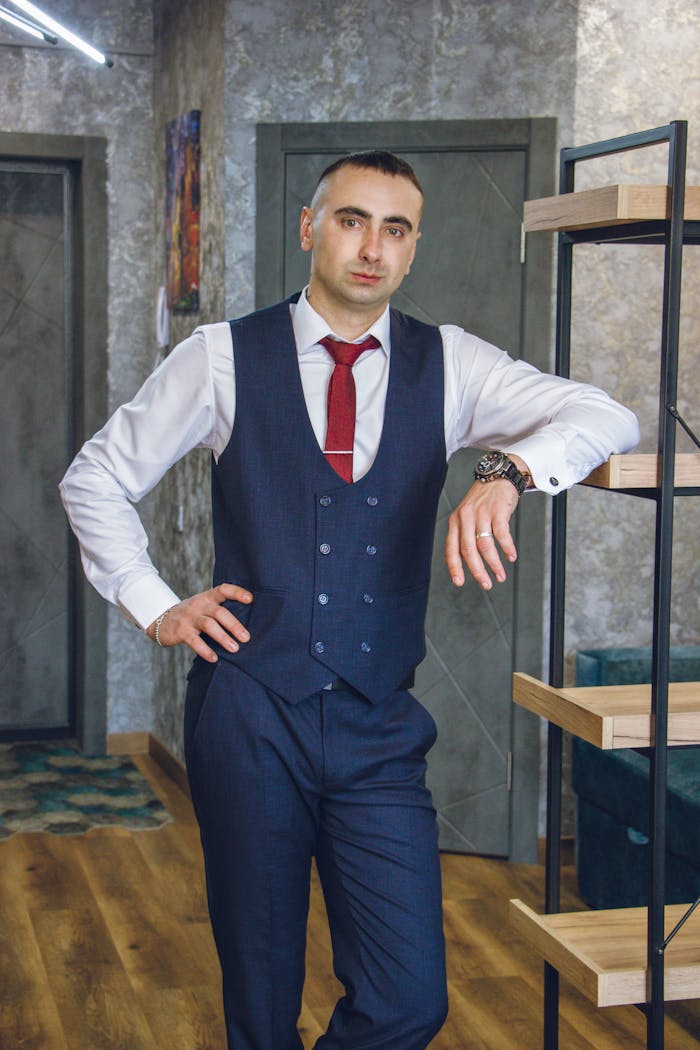 Well-dressed businessman posing in a modern office setting with a confident posture.
