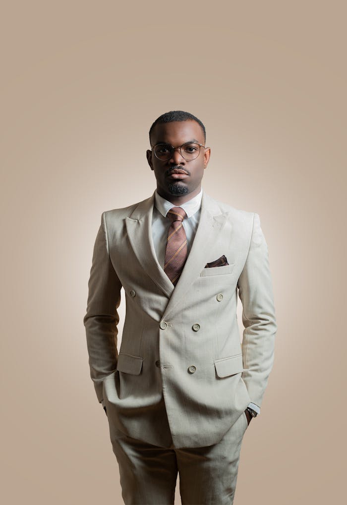 services-02 A fashionable man in a light suit stands confidently against a neutral background.